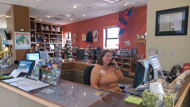a woman sitting at a desk near a gift shop