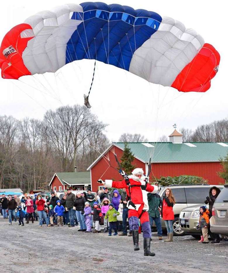 santa parachuting down on a red white and blue parachute