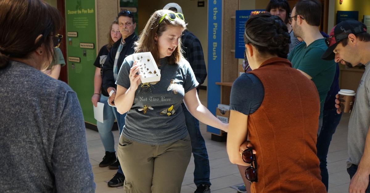 Woman holding white item showing it to a crowd of people in a demonstration